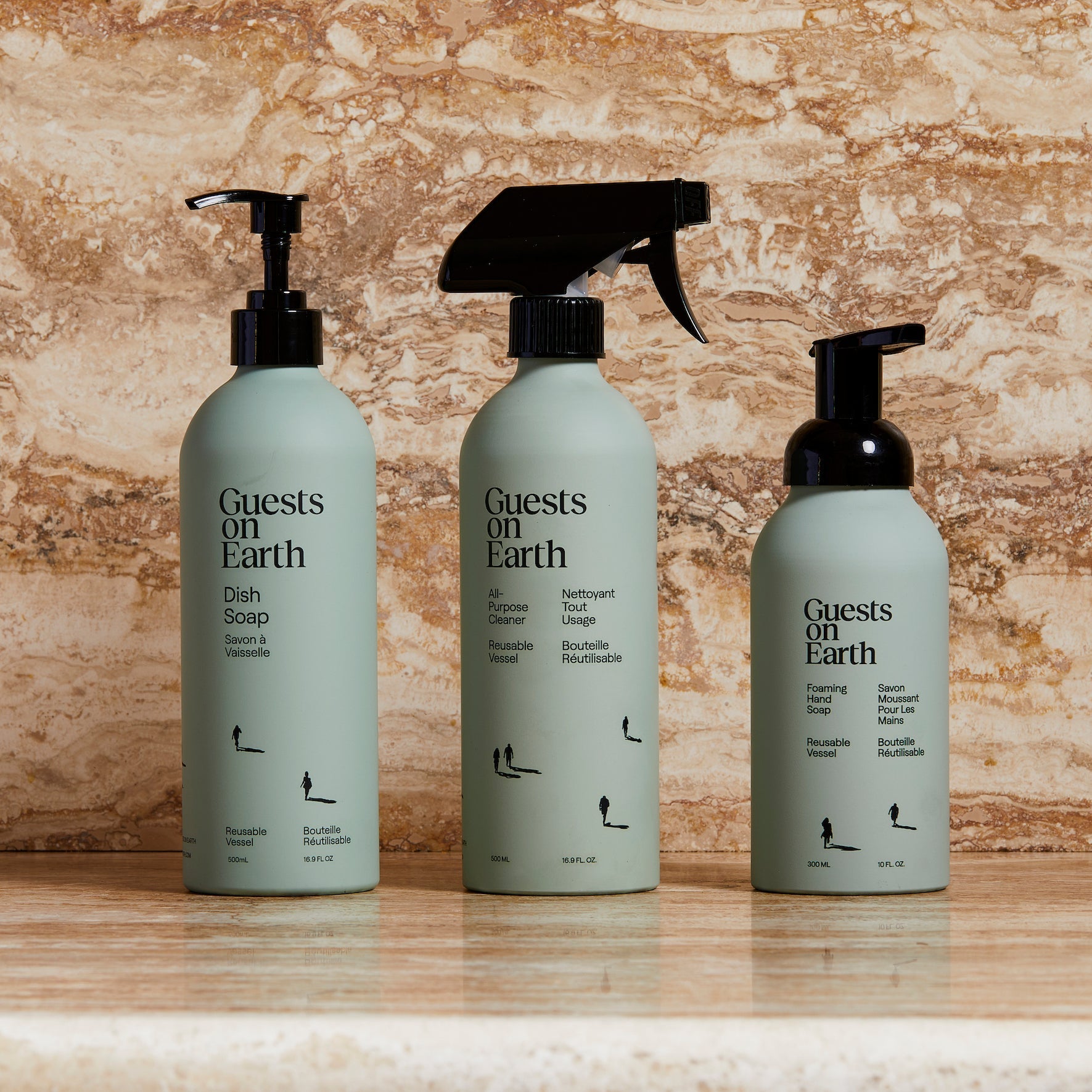 Guests on Earth non-toxic cleaning products: dish soap, all-purpose spray, and foaming hand soap bottles on a marble counter