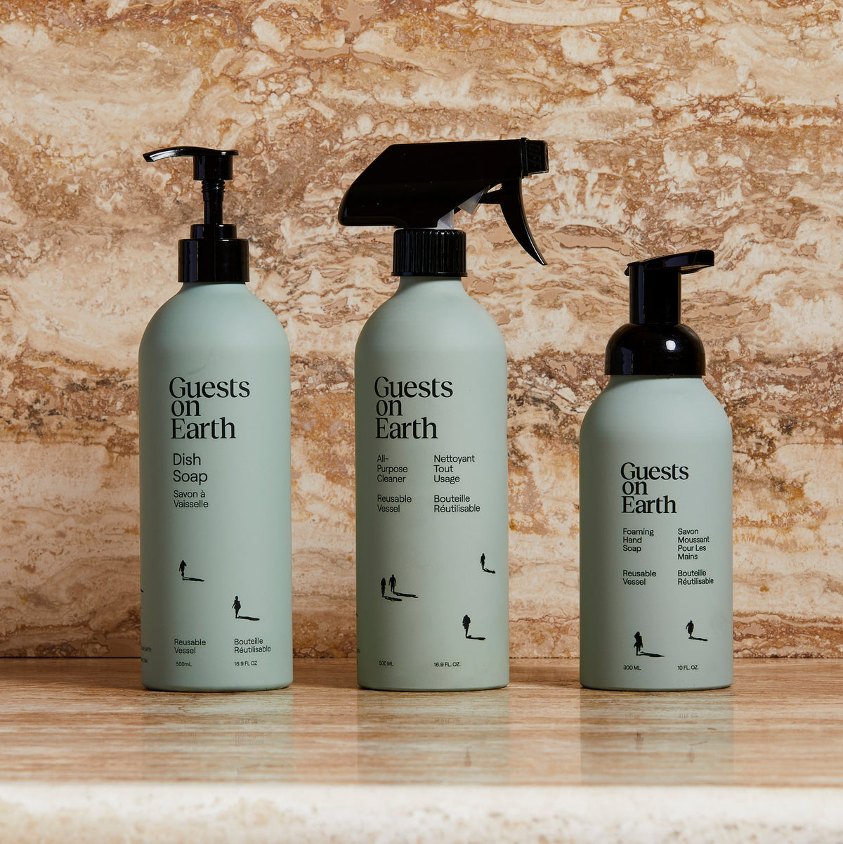 Guests on Earth non-toxic cleaning products: dish soap, all-purpose spray, and foaming hand soap bottles on a marble counter