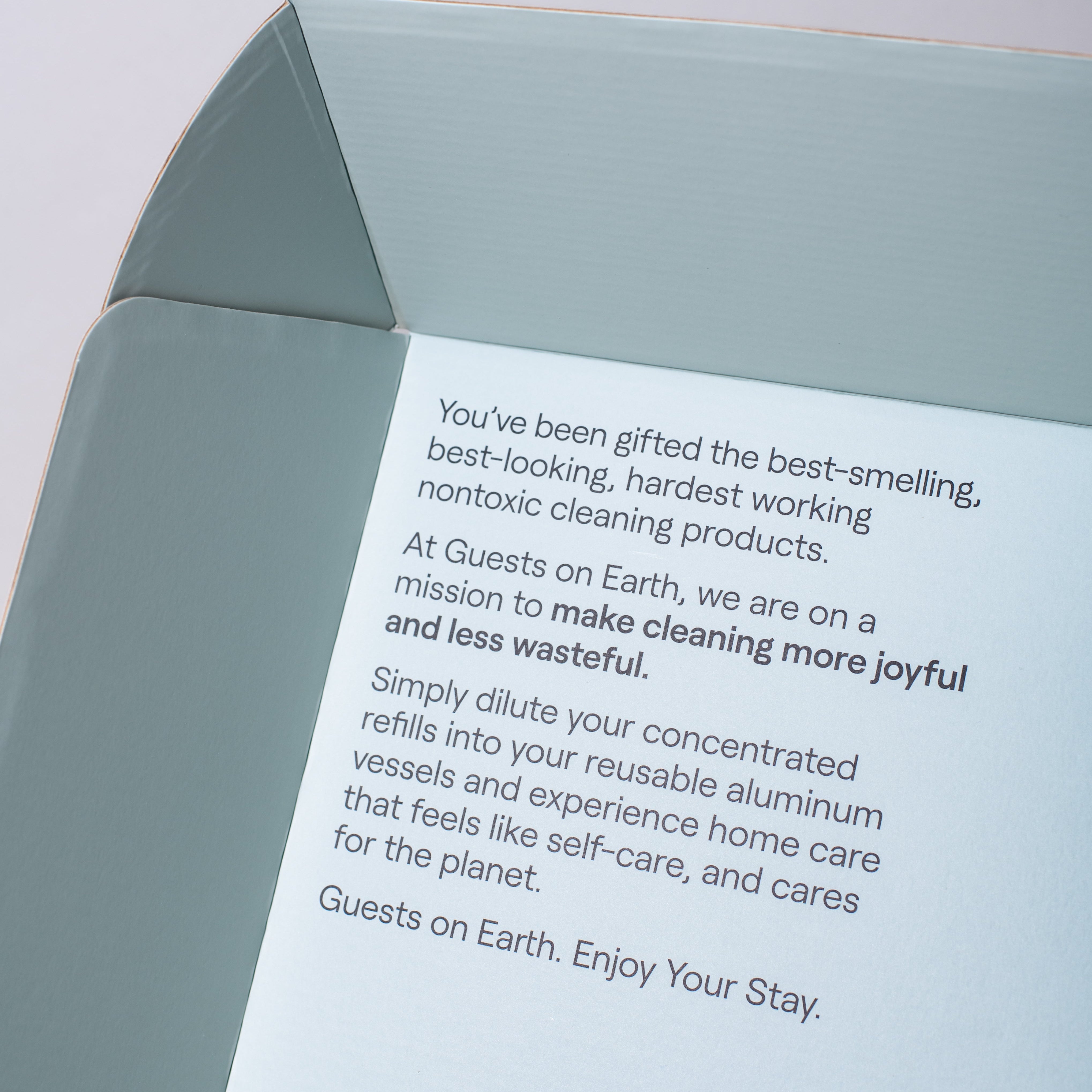 Inside Guests on Earth Gift Box, printed note explains non-toxic refills and reusable aluminium vessels for joyful, low-waste cleaning.