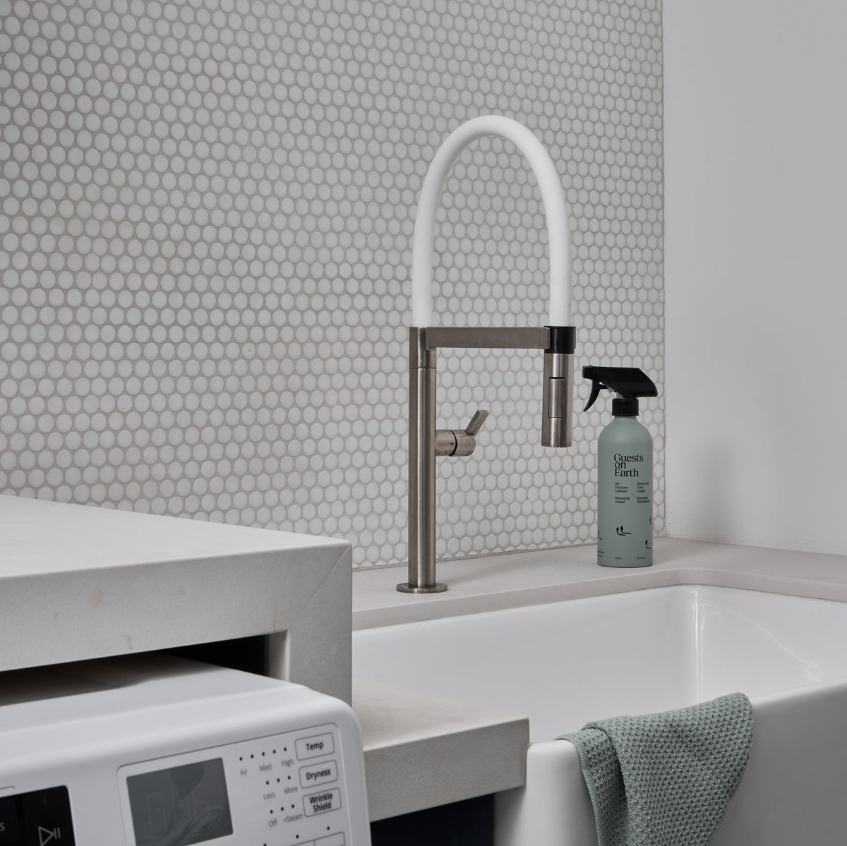 Guests on Earth All-Purpose Cleaner beside a utility sink and washer in a bright laundry room, ready for quick wipe-downs