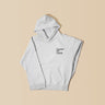 Guests on Earth Hoodie in heather grey with minimalist chest logo, laid flat on a warm beige background